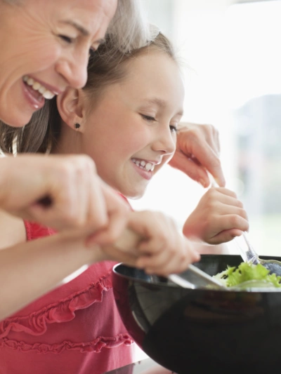 Mother preparing salad with her daughter
